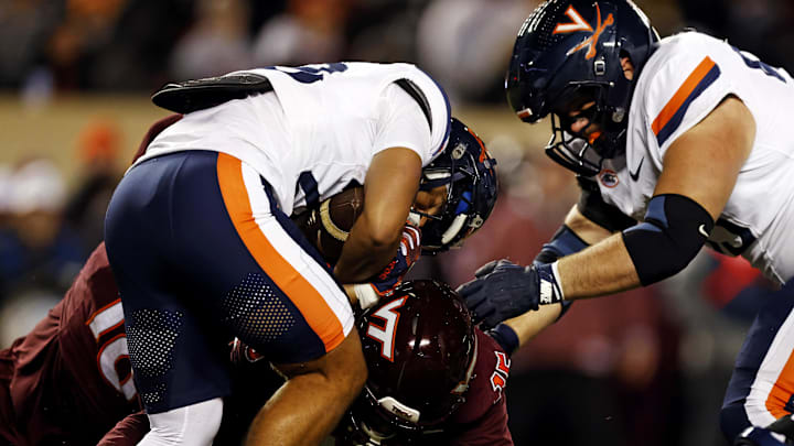 Nov 30, 2024; Blacksburg, Virginia, USA; Virginia Cavaliers running back Noah Vaughn (28) runs the ball against Virginia Tech Hokies safety Jaylen Jones (15) during the first quarter at Lane Stadium. Mandatory Credit: Peter Casey-Imagn Images Nov 30, 2024; Blacksburg, Virginia, USA; Virginia Cavaliers running back Noah Vaughn (28) runs the ball against Virginia Tech Hokies safety Jaylen Jones (15) during the first quarter at Lane Stadium. Mandatory Credit: Peter Casey-Imagn Images