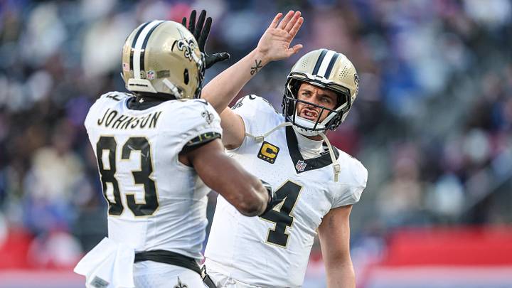 Dec 8, 2024; East Rutherford, New Jersey, USA; New Orleans Saints tight end Juwan Johnson (83) celebrates his touchdown reception from quarterback Derek Carr (4) during the second half against the New York Giants at MetLife Stadium. Mandatory Credit: Vincent Carchietta-Imagn Images