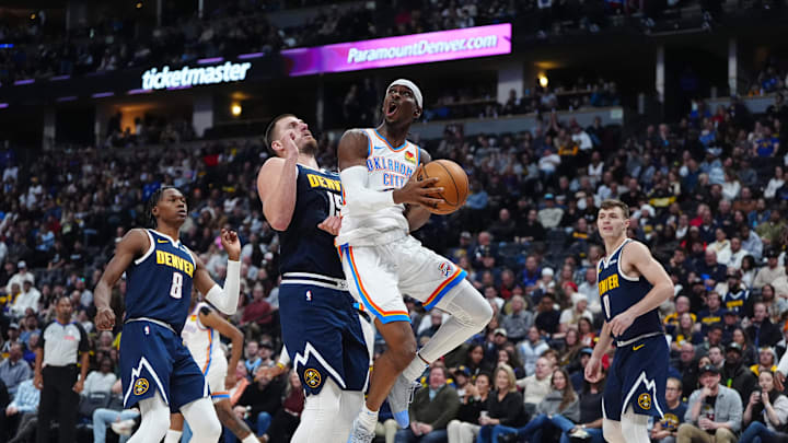 Nov 6, 2024; Denver, Colorado, USA; Oklahoma City Thunder guard Shai Gilgeous-Alexander (2) shoots the ball past Denver Nuggets center Nikola Jokic (15) in the second quarter at Ball Arena. Mandatory Credit: Ron Chenoy-Imagn Images