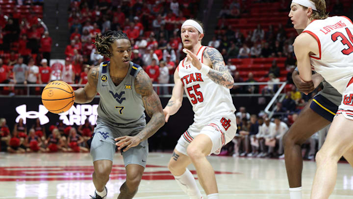 Mar 4, 2025; Salt Lake City, Utah, USA; West Virginia Mountaineers guard Javon Small (7) drives to the basket against Utah Utes guard Gabe Madsen (55) during the first half at Jon M. Huntsman Center. Mandatory Credit: Rob Gray-Imagn Images