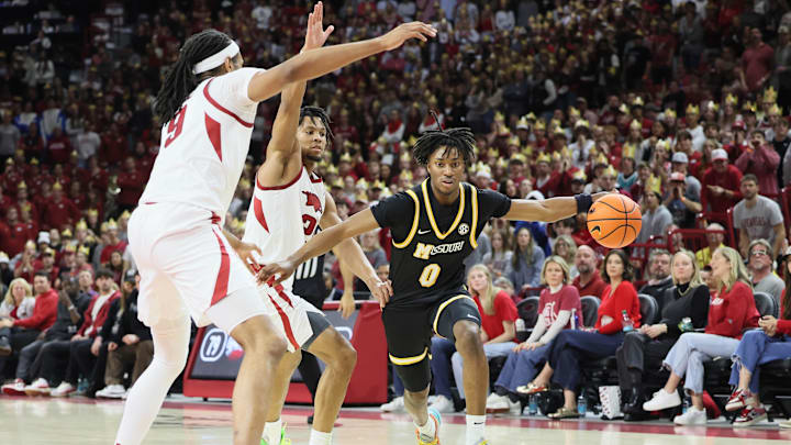 Feb 22, 2025; Fayetteville, Arkansas, USA; Missouri Tigers guard Anthony Robinson III (0) drives against Arkansas Razorbacks forwards Jonas Aidoo (9) and guard D.J. Wagner (21) during the second half at Bud Walton Arena. Mandatory Credit: Nelson Chenault-Imagn Images