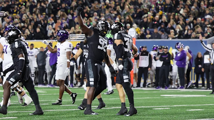 West Virginia University defensive lineman Asani Redwood (92) celebrates with linebacker Chase Wilson (30) against TCU.