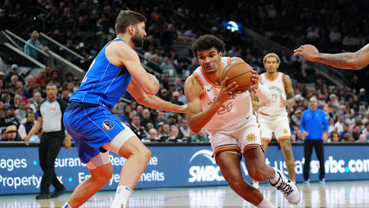 Mar 19, 2024; San Antonio, Texas, USA;  San Antonio Spurs forward Dominick Barlow (26) drives against Dallas Mavericks forward Maxi Kleber (42) in the first half at Frost Bank Center. Mandatory Credit: Daniel Dunn-Imagn Images