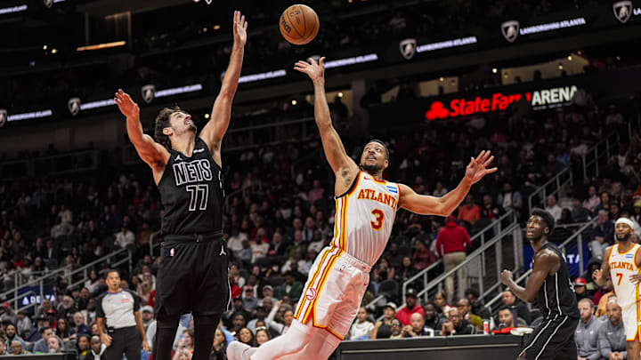 Mar 12, 2026; Atlanta, Georgia, USA; Atlanta Hawks guard CJ McCollum (3) shoots as he falls against Brooklyn Nets guard Ben Saraf (77) during the second half at State Farm Arena. Mandatory Credit: Dale Zanine-Imagn Images