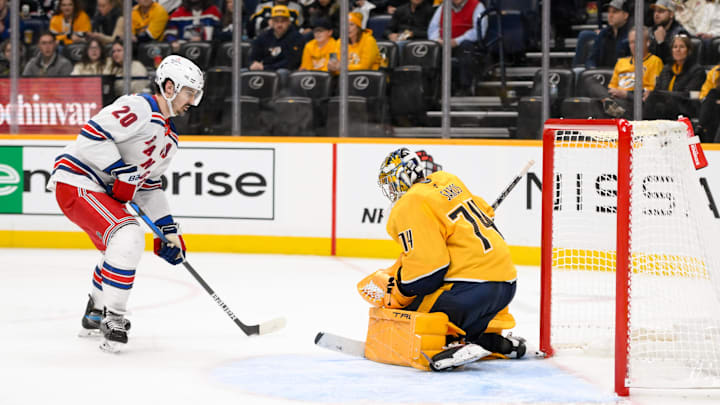 Dec 17, 2024; Nashville, Tennessee, USA;  Nashville Predators goaltender Juuse Saros (74) blocks the shot of New York Rangers left wing Chris Kreider (20) during the second period at Bridgestone Arena. Mandatory Credit: Steve Roberts-Imagn Images