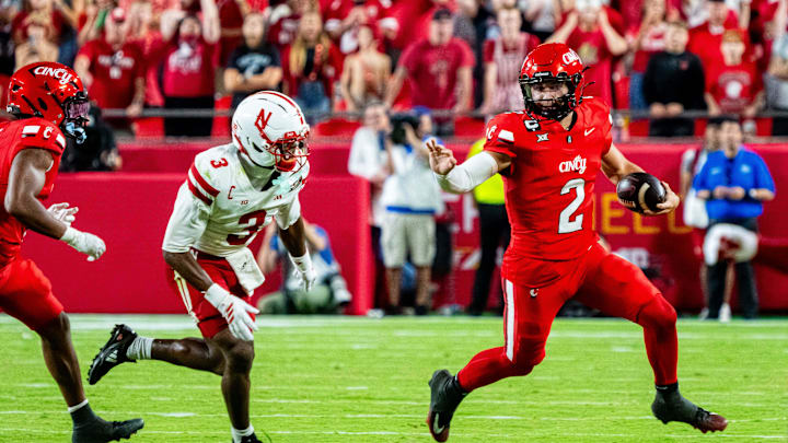 Aug 28, 2025; Kansas City, Missouri, USA; Cincinnati Bearcats quarterback Brendan Sorsby (2) scrambles against Nebraska Cornhuskers defensive back Marques Buford Jr. (3) during the fourth quarter at GEHA Field at Arrowhead Stadium. Mandatory Credit: Dylan Widger-Imagn Images