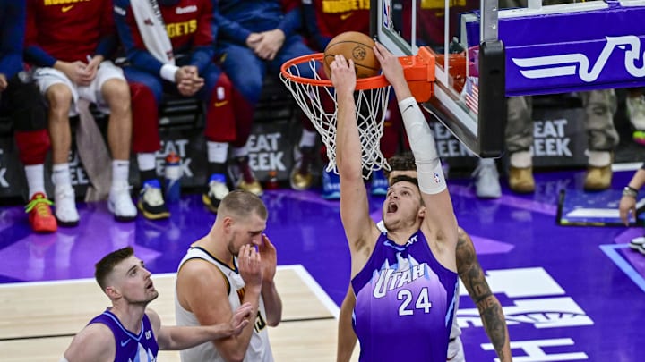 Nov 27, 2024; Salt Lake City, Utah, USA; Utah Jazz center Walker Kessler (24) reverse dunks over Denver Nuggets center Nikola Jokic (15) and forward Michael Porter Jr. (1) during the second half at the Delta Center. Mandatory Credit: Christopher Creveling-Imagn Images