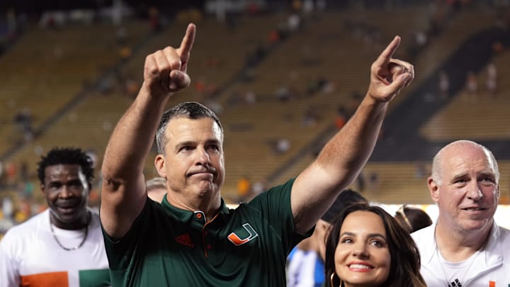Oct 5, 2024; Berkeley, California, USA; Miami Hurricanes head coach Mario Cristobal (center left) gestures to fans with wife Jessica (center right) after defeating the California Golden Bears at California Memorial Stadium. Mandatory Credit: Darren Yamashita-Imagn Images