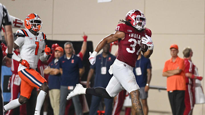 Sep 20, 2025; Bloomington, Indiana, USA; Indiana Hoosiers tight end Riley Nowakowski (37) runs for a touchdown past Illinois Fighting Illini defensive back Kaleb Patterson (1) during the first half at Memorial Stadium. Mandatory Credit: Robert Goddin-Imagn Images