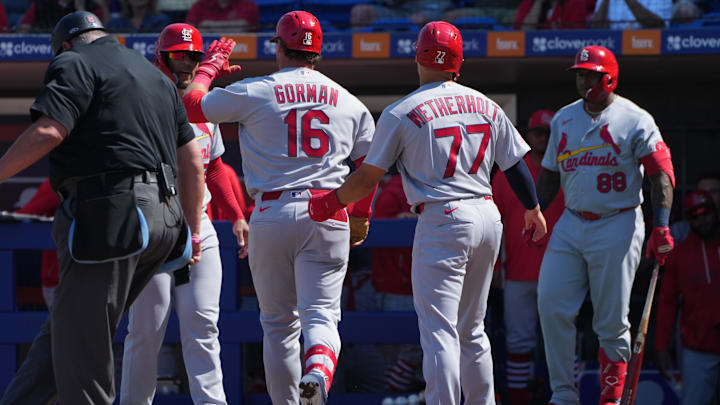 Feb 25, 2026; Port St. Lucie, Florida, USA;  St. Louis Cardinals second baseman Nolan Gorman (16) celebrates  a three-run home run against the New York Mets in the third inning with teammates Chase Davis, left, and JJ Wetherholt (77) at Clover Park. Mandatory Credit: Jim Rassol-Imagn Images