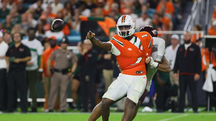 Sep 27, 2024; Miami Gardens, Florida, USA; Miami Hurricanes quarterback Cam Ward (1) throws the football as Virginia Tech Hokies defensive lineman Wilfried Pene (91) attempts a tackle during the second quarter at Hard Rock Stadium. Mandatory Credit: Sam Navarro-Imagn Images Sep 27, 2024; Miami Gardens, Florida, USA; Miami Hurricanes quarterback Cam Ward (1) throws the football as Virginia Tech Hokies defensive lineman Wilfried Pene (91) attempts a tackle during the second quarter at Hard Rock Stadium. Mandatory Credit: Sam Navarro-Imagn Images