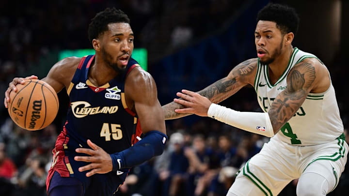 Nov 30, 2025; Cleveland, Ohio, USA; Cleveland Cavaliers guard Donovan Mitchell (45) drives on Boston Celtics guard Anfernee Simons (4) during the second half at Rocket Arena. Mandatory Credit: David Dermer-Imagn Images