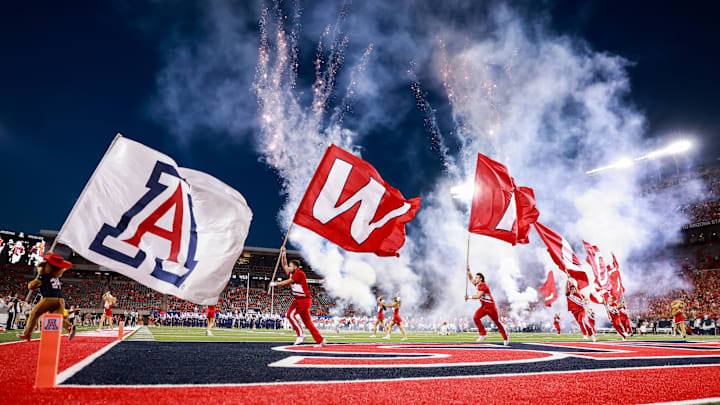 Sep 7, 2024; Tucson, Arizona, USA; Arizona Wildcats cheerleaders runout with flags as they lead the team onto the field before the game against Northern Arizona Lumberjacks at Arizona Stadium. Mandatory Credit: Aryanna Frank-Imagn Images