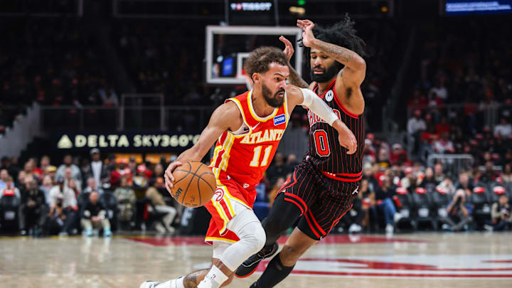Dec 23, 2025; Atlanta, Georgia, USA; Atlanta Hawks guard Trae Young (11) dribbles the ball toward the basket against Chicago Bulls guard Coby White (0) during the first quarter at State Farm Arena. Mandatory Credit: Jordan Godfree-Imagn Images