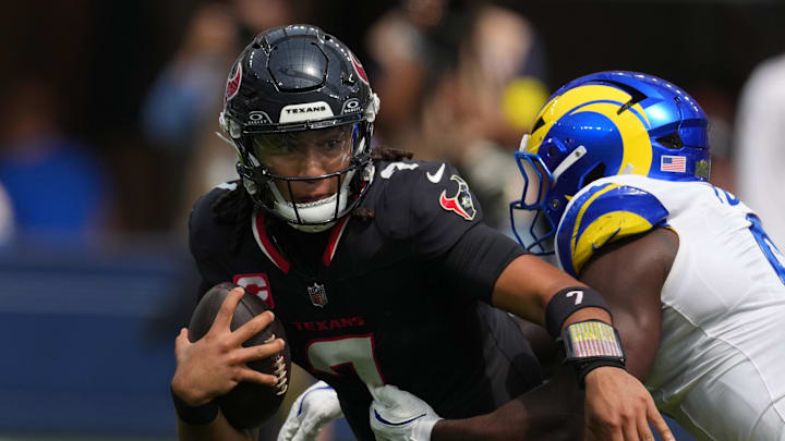 Sep 7, 2025; Inglewood, California, USA; Houston Texans quarterback C.J. Stroud (7) is pressured by Los Angeles Rams linebacker Byron Young (0) in the first half at SoFi Stadium. Mandatory Credit: Kirby Lee-Imagn Images