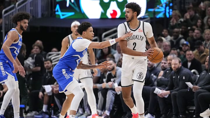 Dec 26, 2024; Milwaukee, Wisconsin, USA;  Brooklyn Nets forward Cameron Johnson (2) looks to pass the ball under pressure from Milwaukee Bucks guard Ryan Rollins (13) during the first quarter  at Fiserv Forum. Mandatory Credit: Jeff Hanisch-Imagn Images