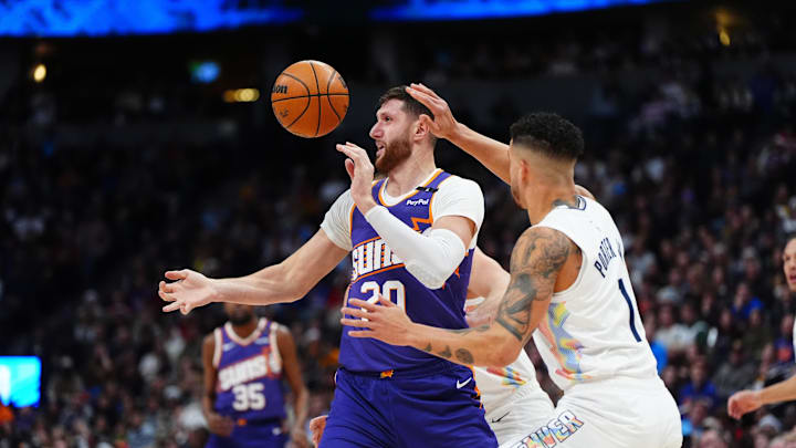 Dec 23, 2024; Denver, Colorado, USA; Phoenix Suns center Jusuf Nurkic (20) and Denver Nuggets forward Michael Porter Jr. (1) reach for a loose ball in the first quarter at Ball Arena. Mandatory Credit: Ron Chenoy-Imagn Images