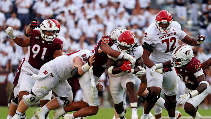 Sep 21, 2024; Blacksburg, Virginia, USA; Rutgers Scarlet Knights running back Kyle Monangai (5) runs the ball against Virginia Tech Hokies linebacker Caleb Woodson (25) during the third quarter at Lane Stadium. Mandatory Credit: Peter Casey-Imagn Images