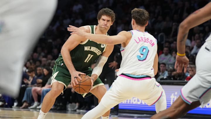 Apr 5, 2025; Miami, Florida, USA;  Milwaukee Bucks center Brook Lopez (11) changes direction as Miami Heat guard Pelle Larsson (9) defends during the second half at Kaseya Center. Mandatory Credit: Jim Rassol-Imagn Images