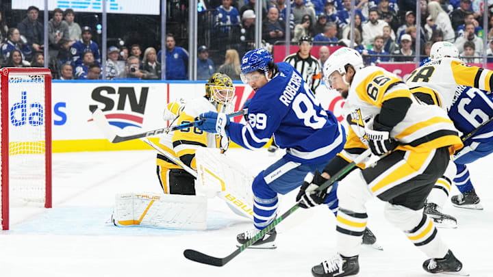 Oct 12, 2024; Toronto, Ontario, CAN; Toronto Maple Leafs left wing Nicholas Robertson (89) battles for the puck with Pittsburgh Penguins defenseman Erik Karlsson (65) during the first period at Scotiabank Arena. Mandatory Credit: Nick Turchiaro-Imagn Images