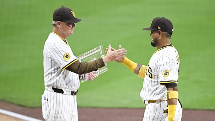 Sep 22, 2025; San Diego, California, USA; San Diego Padres first baseman Luis Arraez (4) receives the San Diego Padres’ “Heart and Hustle” award from manager Mike Shildt (8) before a game against the Milwaukee Brewers at Petco Park. Mandatory Credit: Denis Poroy-Imagn Images