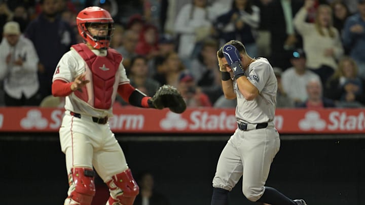 May 30, 2024; Anaheim, California, USA;  New York Yankees shortstop Anthony Volpe (11) ducks as he scores on a triple by right fielder Juan Soto (22) in the seventh inning against the Los Angeles Angels at Angel Stadium. Mandatory Credit: Jayne Kamin-Oncea-USA TODAY Sports