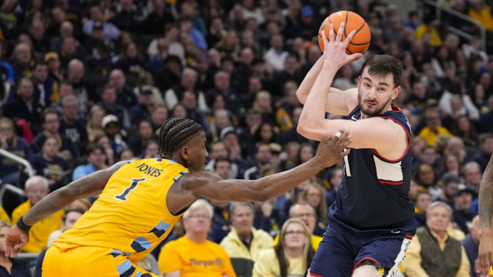 Feb 1, 2025; Milwaukee, Wisconsin, USA; Connecticut Huskies forward Alex Karaban (11) drives for the basket around Marquette Golden Eagles guard Kam Jones (1) during the first half at Fiserv Forum. Mandatory Credit: Jeff Hanisch-Imagn Images Feb 1, 2025; Milwaukee, Wisconsin, USA; Connecticut Huskies forward Alex Karaban (11) drives for the basket around Marquette Golden Eagles guard Kam Jones (1) during the first half at Fiserv Forum. Mandatory Credit: Jeff Hanisch-Imagn Images