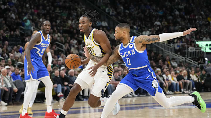 Mar 15, 2025; Milwaukee, Wisconsin, USA;  Indiana Pacers forward Aaron Nesmith (23) drives for the basket against  Milwaukee Bucks' Damian Lillard (0) during the first quarter at Fiserv Forum. Mandatory Credit: Jeff Hanisch-Imagn Images