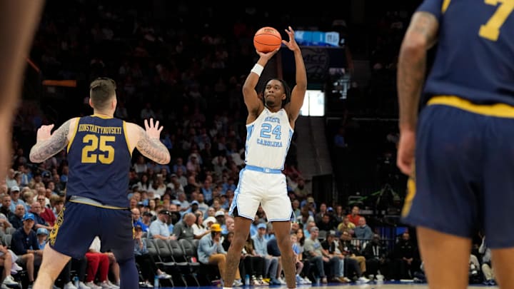 Mar 12, 2025; Charlotte, NC, USA; North Carolina Tar Heels forward Jae'Lyn Withers (24) shoots a three point shot as Notre Dame Fighting Irish forward Nikita Konstantynovskyi (25) defends in the first half at Spectrum Center. Mandatory Credit: Bob Donnan-Imagn Images