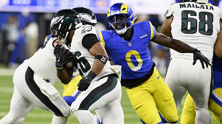 Nov 24, 2024; Inglewood, California, USA;  Los Angeles Rams linebacker Byron Young (0) chases after Philadelphia Eagles running back Saquon Barkley (26) during the first half at SoFi Stadium. Mandatory Credit: Alex Gallardo-Imagn Images
