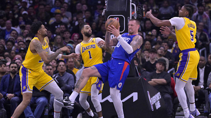 Jan 23, 2024; Los Angeles, California, USA; Los Angeles Clippers center Daniel Theis (10) is surrounded by Los Angeles Lakers forward Christian Wood (35), guard D'Angelo Russell (1) and forward Cam Reddish (5) as he holds on to a rebound in the second half at Crypto.com Arena. Mandatory Credit: Jayne Kamin-Oncea-Imagn Images