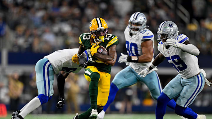 Sep 28, 2025; Arlington, Texas, USA; Dallas Cowboys safety Donovan Wilson (6) attempts to tackle Green Bay Packers wide receiver Dontayvion Wicks (13) during the game between the Dallas Cowboys and the Green Bay Packers at AT&T Stadium. Mandatory Credit: Jerome Miron-Imagn Images