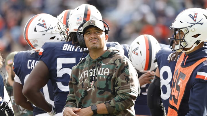 Nov 23, 2024; Charlottesville, Virginia, USA; Virginia Cavaliers head coach Tony Elliott (center) looks on from the field during a stoppage in play in the first half against the Southern Methodist Mustangs at Scott Stadium. Mandatory Credit: Amber Searls-Imagn Images