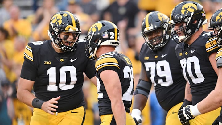 Sep 16, 2023; Iowa City, Iowa, USA; Iowa Hawkeyes quarterback Deacon Hill (10) celebrates with running back Max White (22), offensive lineman Beau Stephens (70), and offensive lineman Daijon Parker (79) after White scored a touchdown late during the fourth quarter against the Western Michigan Broncos at Kinnick Stadium. Mandatory Credit: Jeffrey Becker-Imagn Images Sep 16, 2023; Iowa City, Iowa, USA; Iowa Hawkeyes quarterback Deacon Hill (10) celebrates with running back Max White (22), offensive lineman Beau Stephens (70), and offensive lineman Daijon Parker (79) after White scored a touchdown late during the fourth quarter against the Western Michigan Broncos at Kinnick Stadium. Mandatory Credit: Jeffrey Becker-Imagn Images