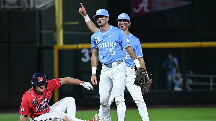 Jun 12, 2026; Omaha, NE, USA; North Carolina Tar Heels shortstop Jake Schaffner (2) and shortstop Jake Schaffner (2) complete a double play as Mississippi Rebels pinch runner Cannon Goldin (4) watches in the ninth inning at Charles Schwab Field. Mandatory Credit: Steven Branscombe-Imagn Images