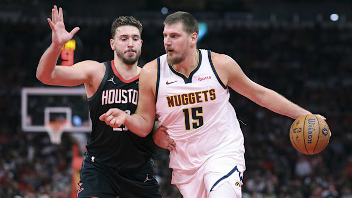 Nov 21, 2025; Houston, Texas, USA; Denver Nuggets center Nikola Jokic (15) controls the ball as Houston Rockets center Alperen Sengun (28) defends during the fourth quarter at Toyota Center. Mandatory Credit: Troy Taormina-Imagn Images