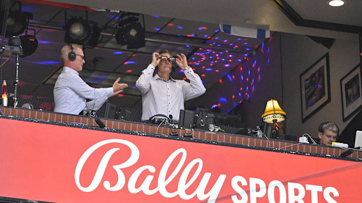 Jul 29, 2024; St. Louis, Missouri, USA;  Bally Sports broadcaster Chip Caray talks with broadcaster Jack Buck during the third inning of a game between the St. Louis Cardinals and the Texas Rangers at Busch Stadium. Mandatory Credit: Jeff Curry-Imagn Images