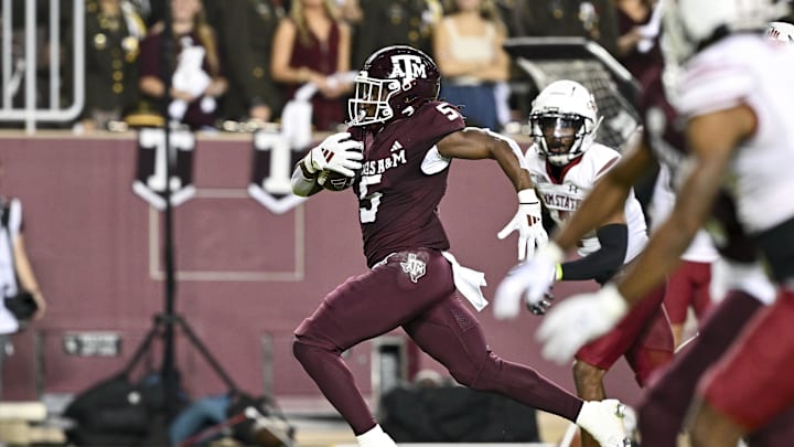Nov 16, 2024; College Station, Texas, USA; Texas A&M Aggies running back Amari Daniels (5) runs the ball during the first half against the New Mexico State Aggies at Kyle Field. Mandatory Credit: Maria Lysaker-Imagn Images 