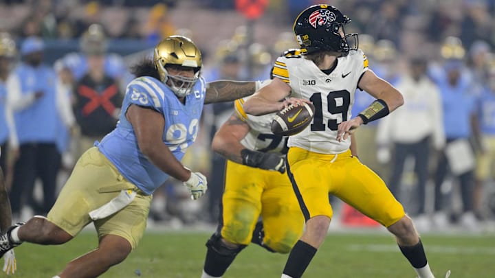 Nov 8, 2024; Pasadena, California, USA;  UCLA Bruins defensive lineman Jay Toia (93) pressures Iowa Hawkeyes quarterback Jackson Stratton (19) as he throws a pass in the second half at the Rose Bowl. Mandatory Credit: Jayne Kamin-Oncea-Imagn Images