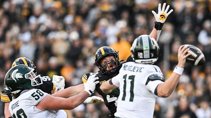 Nov 22, 2025; Iowa City, Iowa, USA; Iowa Hawkeyes defensive end Max Llewellyn (center with arm raised) rushes Michigan State Spartans quarterback Alessio Milivojevic (11) as offensive lineman Conner Moore (58) blocks during the second quarter at Kinnick Stadium. Mandatory Credit: Jeffrey Becker-Imagn Images