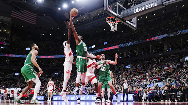 Oct 15, 2024; Toronto, Ontario, CAN; Boston Celtics forward Xavier Tillman (26) battles for the rebound against Toronto Raptors forward Chris Boucher (25) during the second half at Scotiabank Arena. Mandatory Credit: Kevin Sousa-Imagn Images