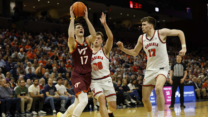 Mar 7, 2026; Charlottesville, Virginia, USA; Virginia Tech Hokies guard Neoklis Avdalas (17) drives to the basket as Virginia Cavaliers guard Dallin Hall (30) and Cavaliers center Johann Grünloh (17) defend in the first half at John Paul Jones Arena. Mandatory Credit: Geoff Burke-Imagn Images