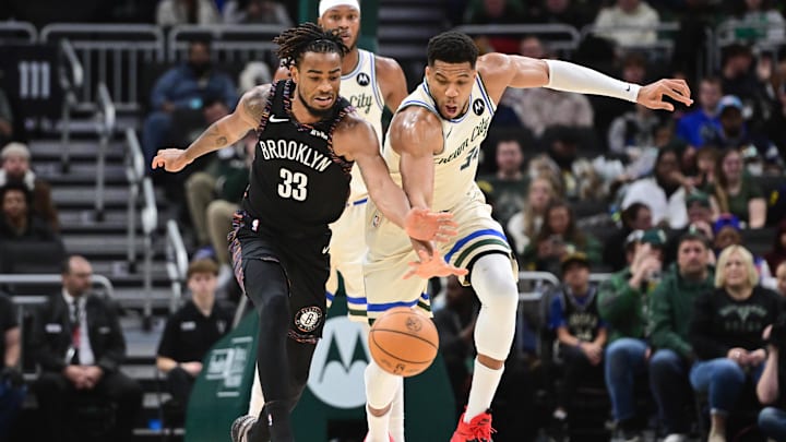 Nov 29, 2025; Milwaukee, Wisconsin, USA;  Brooklyn Nets center Nicolas Claxton (33) and Milwaukee Bucks forward Giannis Antetokounmpo (34) reach for a loose ball in the first quarter at Fiserv Forum. Mandatory Credit: Benny Sieu-Imagn Images