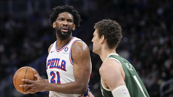 Feb 9, 2025; Milwaukee, Wisconsin, USA;  Philadelphia 76ers center Joel Embiid (21) holds the ball as Milwaukee Bucks center Brook Lopez (11) defends during the second quarter at Fiserv Forum. Mandatory Credit: Jeff Hanisch-Imagn Images
