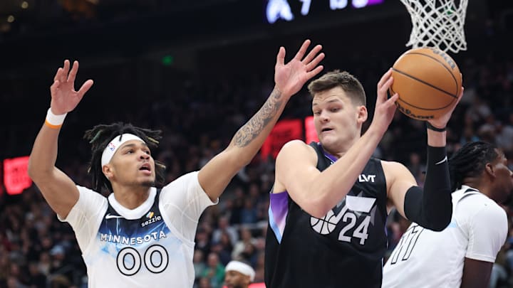 Feb 28, 2025; Salt Lake City, Utah, USA; Utah Jazz center Walker Kessler (24) rebounds against Minnesota Timberwolves guard Terrence Shannon Jr. (00) during the first quarter at Delta Center. Mandatory Credit: Rob Gray-Imagn Images
