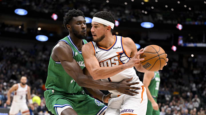 Nov 12, 2025; Dallas, Texas, USA; Phoenix Suns guard Devin Booker (1) looks to move the ball to the basket past Dallas Mavericks center Moussa Cisse (30) during the second half at the American Airlines Center. Mandatory Credit: Jerome Miron-Imagn Images