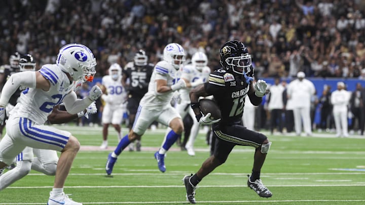 Dec 28, 2024; San Antonio, TX, USA; Colorado Buffaloes wide receiver Travis Hunter (12) runs with the ball and scores a touchdown during the third quarter against the Brigham Young Cougars at Alamodome. Mandatory Credit: Troy Taormina-Imagn Images