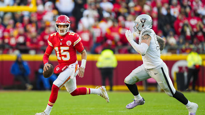 Nov 29, 2024; Kansas City, Missouri, USA; Kansas City Chiefs quarterback Patrick Mahomes (15) scrambles against Las Vegas Raiders defensive end Maxx Crosby (98) during the first half at GEHA Field at Arrowhead Stadium. Mandatory Credit: Jay Biggerstaff-Imagn Images