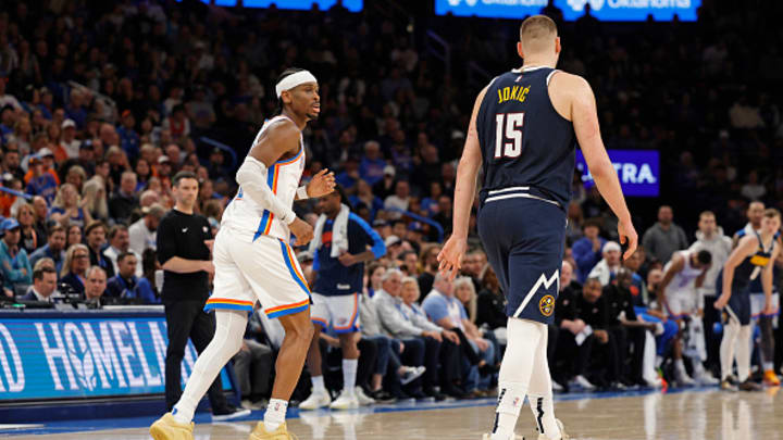 Mark Daigneault and Shai Gilgeous-Alexander watch Nikola Jokic during a Nuggets win over OKC.