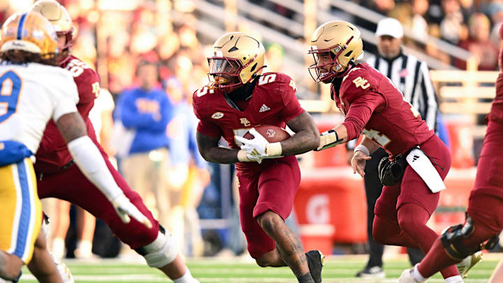 Nov 30, 2024; Chestnut Hill, Massachusetts, USA; Boston College Eagles quarterback Grayson James (14) hands the ball off to running back Kye Robichaux (5) during the first half of a game against the Pittsburgh Panthers at Alumni Stadium. Mandatory Credit: Brian Fluharty-Imagn Images